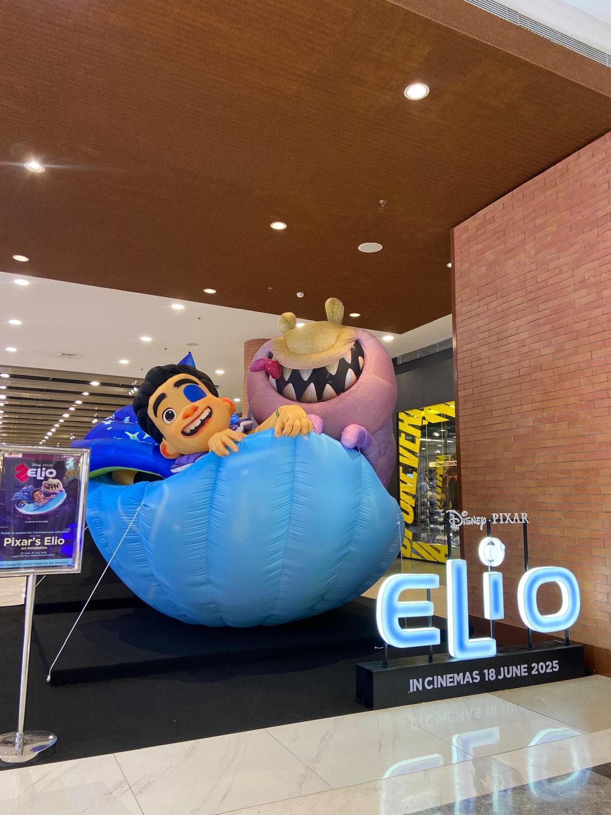 Inflatable gergasi Elio dan watak makhluk asing dalam pod biru, dibina untuk Disney Indonesia dan dipasang di atrium pusat beli-belah