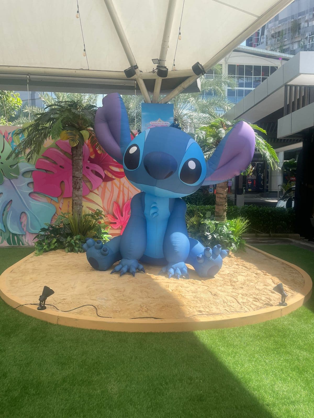 Inflatable Stitch bersaiz besar dalam kedudukan duduk di atas paparan pasir di Pakuwon City Mall, Indonesia