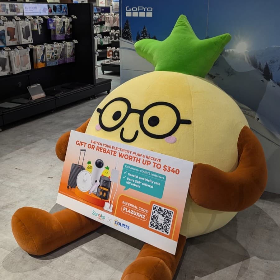 BB Ong Lai, paparan plushie nanas gergasi untuk Senoko Energy yang memegang papan kempen di sebuah kedai